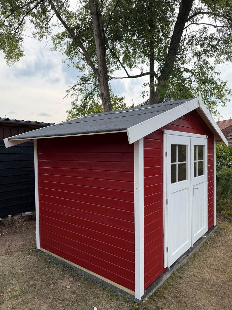 Fertig gebautes rotes Gartenhaus im Garten, Rheingau