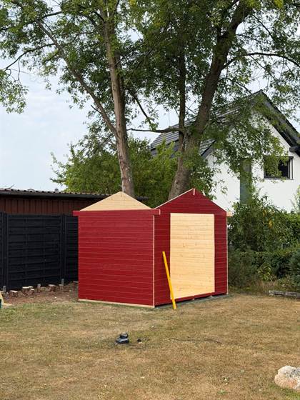 Gartenhaus im Rohbau mit roter Holzverkleidung